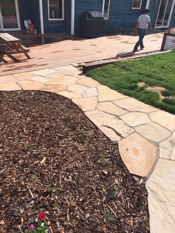 Flagstone walkway curving through fresh lawn